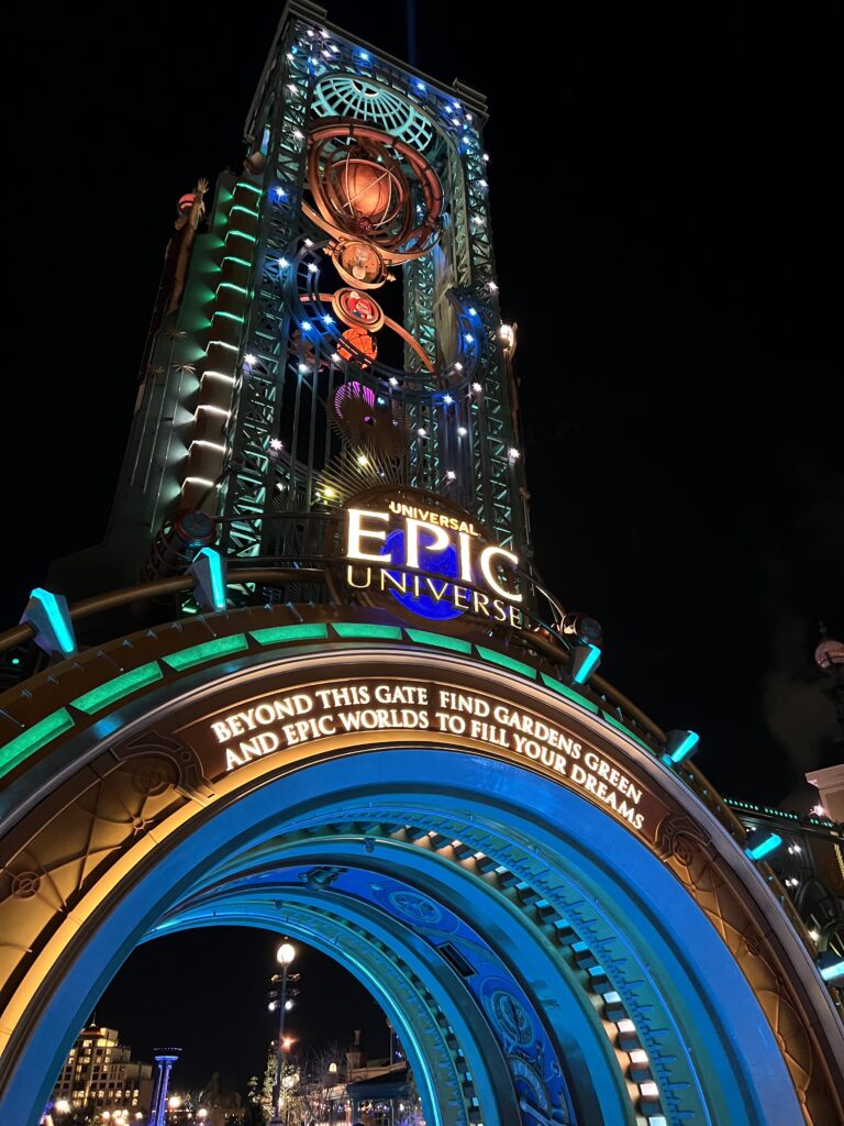 a picture of the icon of Epic Universe, the Chronos. A larger tower made of interlaced steel with many rotating parts, similar to an astrolabe, atop a cylindrical portal.