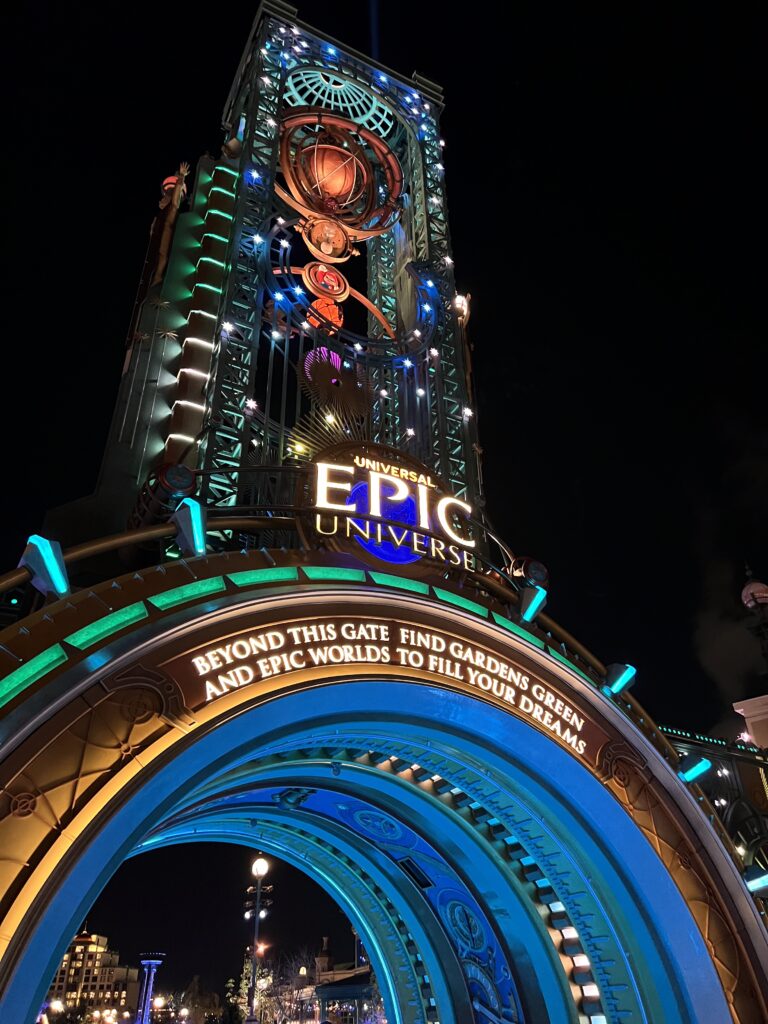 a picture of the icon of Epic Universe, the Chronos. A larger tower made of interlaced steel with many rotating parts, similar to an astrolabe, atop a cylindrical portal.
